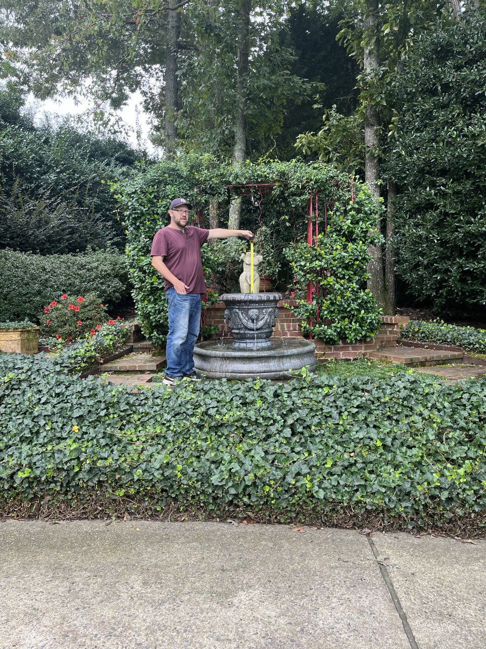 Josh measuring a fountain during a service call