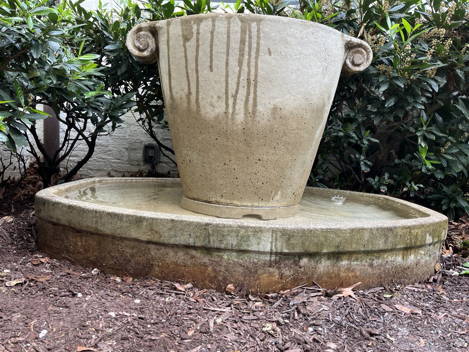 Urn fountain raised on gravel base after releveling, Raleigh NC